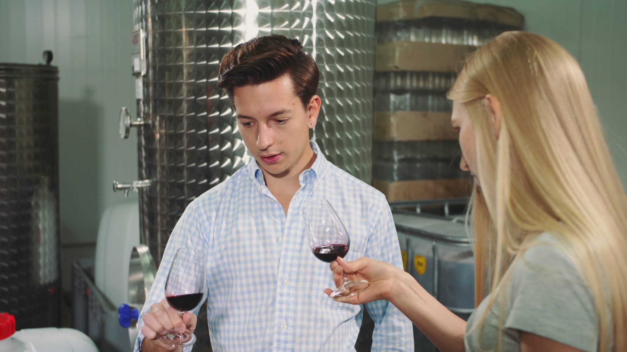 un homme et une femme tenant du vin dans une biere min