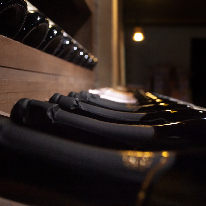 Bouteilles de vin couchées sur étagère en bois